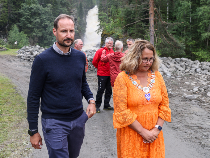 Kronprins Haakon får en omvisning ved Fallelva og orientering om situasjonen i Søndre Land ved ordfører Anne Hagenborg. Foto: Geir Olsen / NTB